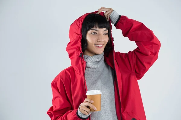 Vrouw in rode jas met koffie — Stockfoto