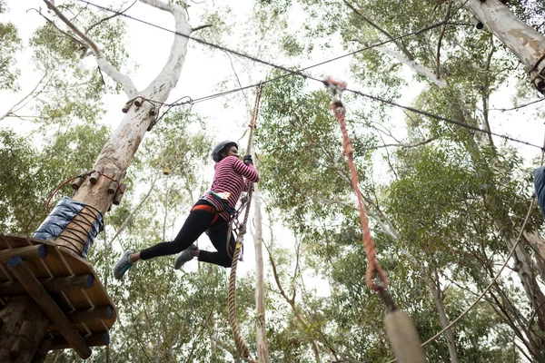 Mujer disfrutando de la aventura tirolesa en el parque — Foto de Stock