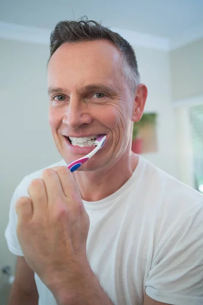 Man brushing his teeth with toothbrush — Stock Photo, Image
