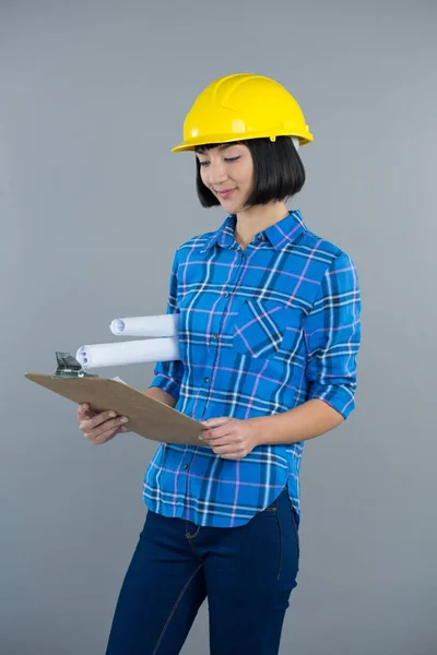 Female architect looking at clipboard — Stock Photo, Image