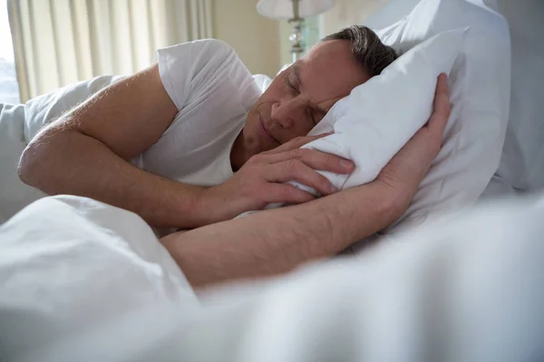 Mann schläft auf Bett im Schlafzimmer — Stockfoto