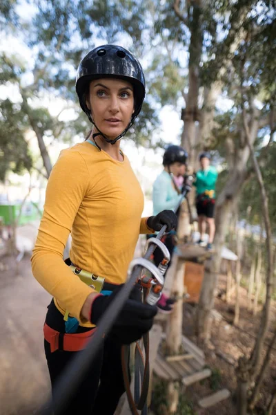 Mulher desfrutando de aventura tirolesa — Fotografia de Stock