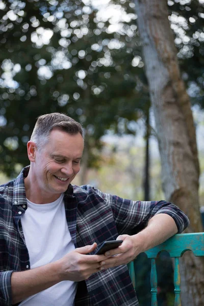 Homme utilisant le téléphone sur banc — Photo