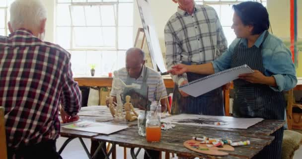 Художники, работающие за столом — стоковое видео