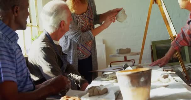 Woman assisting artist in pottery — Stock Video