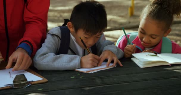 Niños y profesores tomando notas — Vídeo de stock