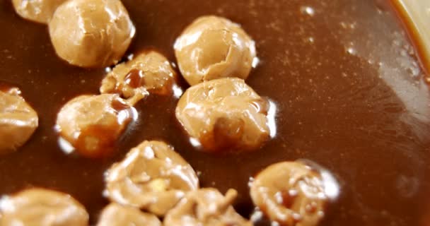 Карамельные шарики в расплавленном шоколаде — стоковое видео