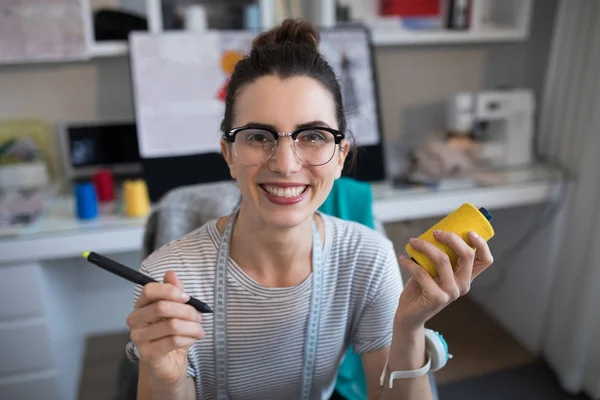 Designer feminina segurando carretel e estilete — Fotografia de Stock