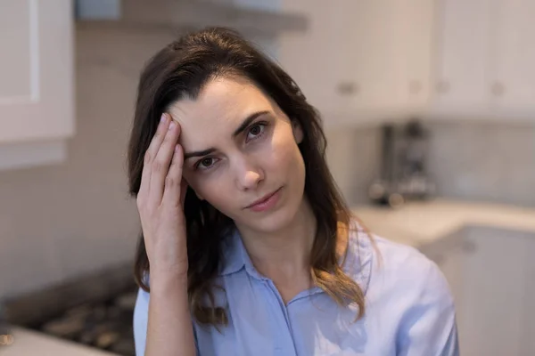 Mujer con dolor de cabeza en la cocina — Foto de Stock