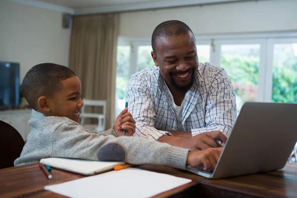 Ojciec i syn korzysta z laptopa w salonie — Zdjęcie stockowe