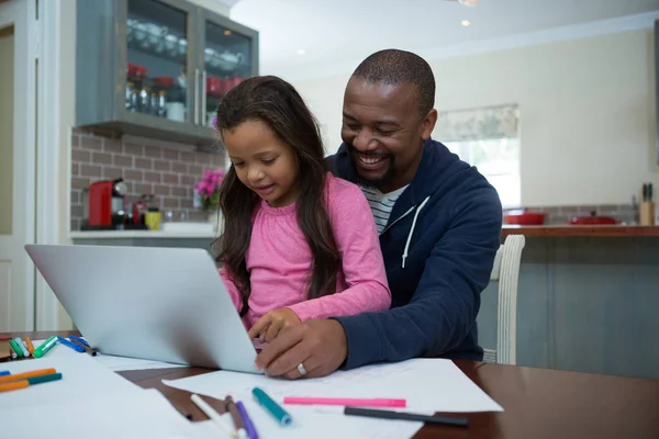 Padre e figlia utilizzando il computer portatile in cucina — Foto Stock