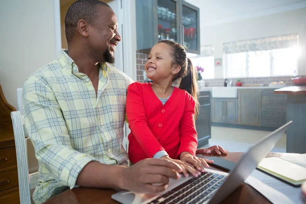 Padre e figlia utilizzando il computer portatile in cucina — Foto Stock