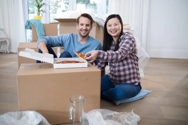 Coppia che mangia pizza nella loro nuova casa — Foto Stock