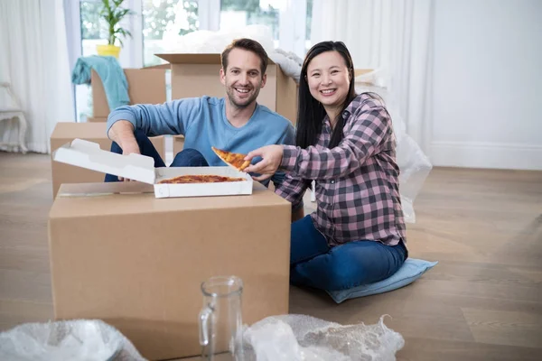 Pareja comiendo pizza en su nuevo hogar — Foto de Stock