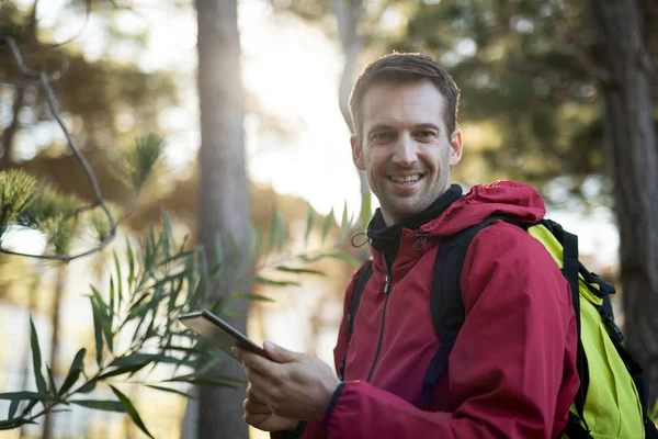 Людина тримає цифровий планшет у лісі — стокове фото