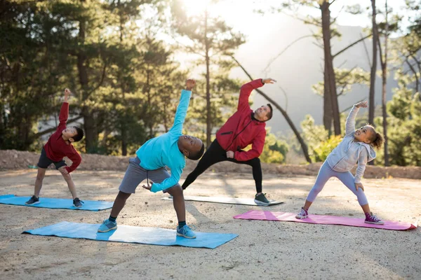 Coach aiutare i bambini a praticare yoga — Foto Stock