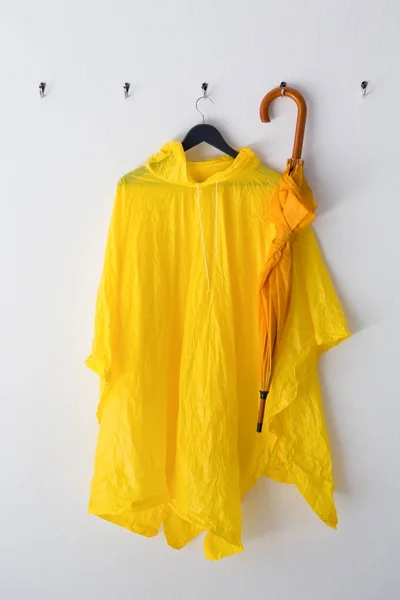 Regenmantel und Regenschirm hängen am Haken — Stockfoto