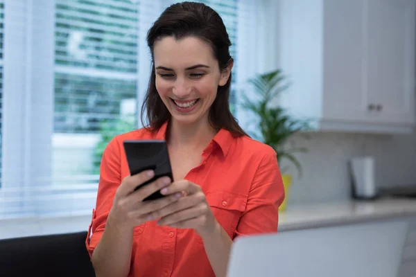 Kvinna som använder mobiltelefon hemma — Stockfoto