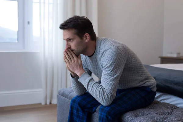 Omtänksamma mannen sitter på sängen — Stockfoto