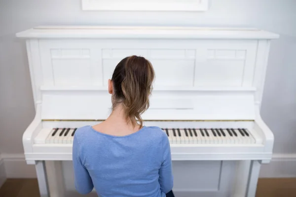 Bakifrån av kvinna spela piano — Stockfoto