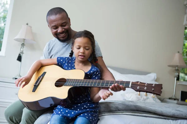 Vader onderwijs zijn dochter om gitaar te spelen — Stockfoto
