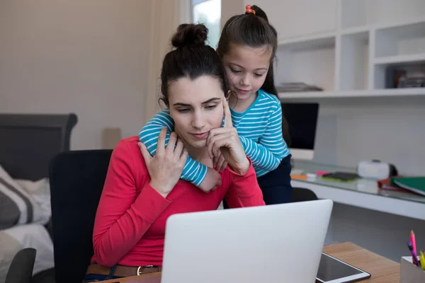 Moeder en dochter met behulp van laptop aan balie — Stockfoto