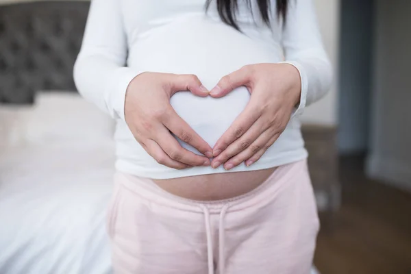 Woman forming heart shape on stomach — Stock Photo, Image