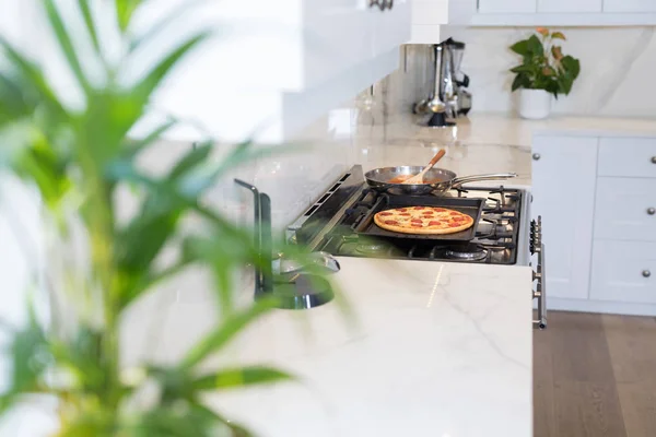 Pizza op bakken lade in keuken — Stockfoto