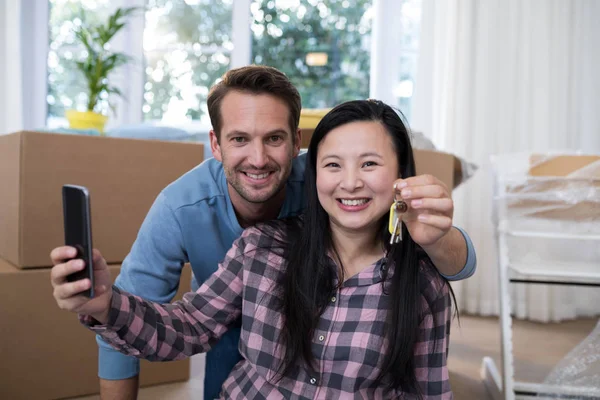 Par som visar en nyckel i deras nya hus — Stockfoto