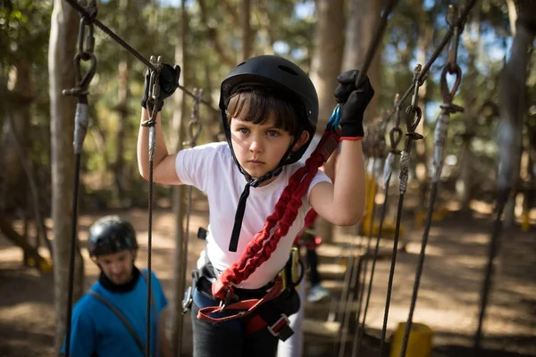 stock image Determined boy crossing zip line