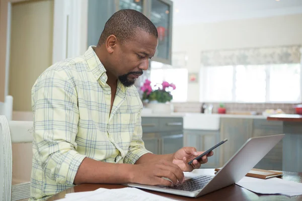 Homem usando laptop e telefone — Fotografia de Stock