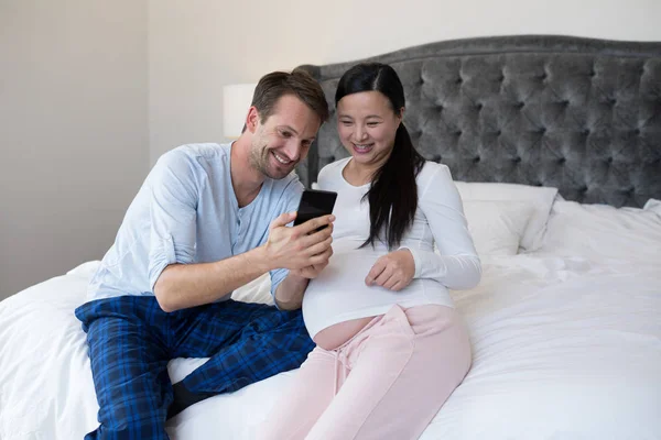 Casal revendo imagem no telefone móvel — Fotografia de Stock