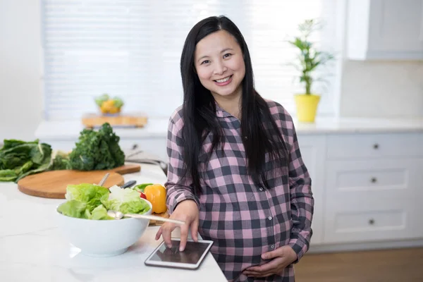 Donna incinta che utilizza tablet in cucina — Foto Stock