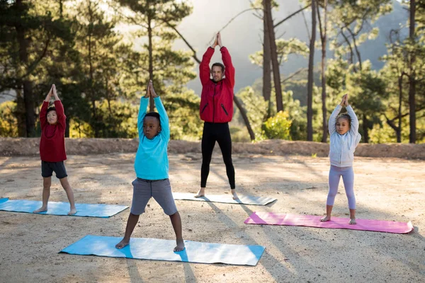 Coach aiutare i bambini a praticare yoga — Foto Stock