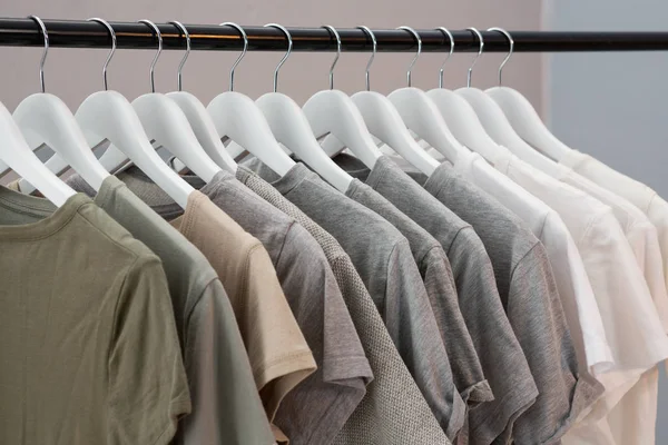 Various t-shirts hanging on cloth hanger — Stock Photo, Image