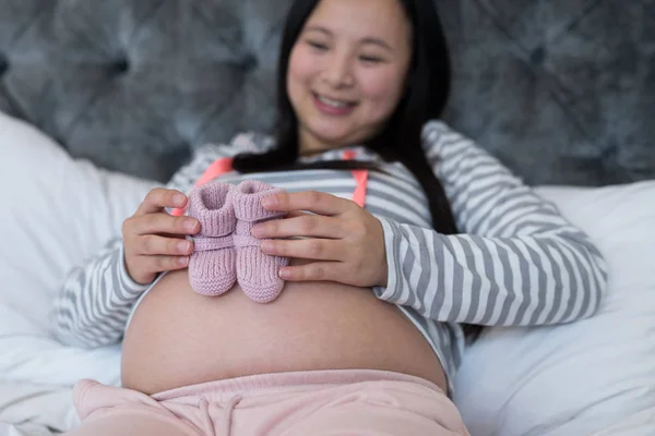 Kobieta w ciąży, patrząc na skarpety — Zdjęcie stockowe
