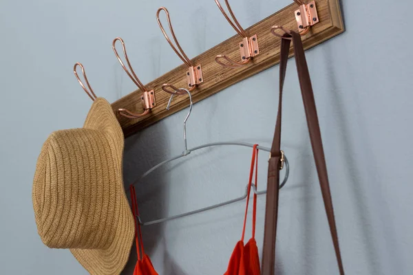 Straw hat, dress and bag hanging on wall — Stock Photo, Image