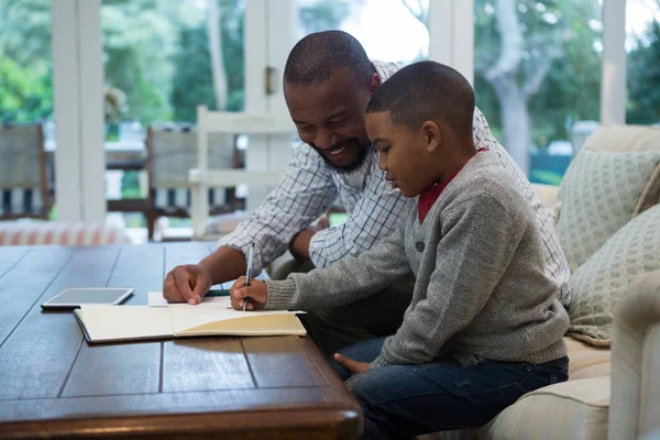 Vader helpt zijn zoon met huiswerk — Stockfoto