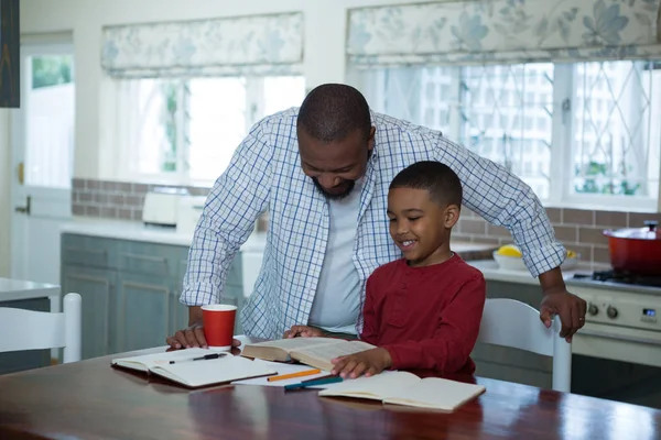 Vader helpt zijn zoon met huiswerk — Stockfoto