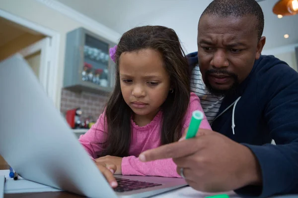 Padre e figlia utilizzando il computer portatile in cucina — Foto Stock