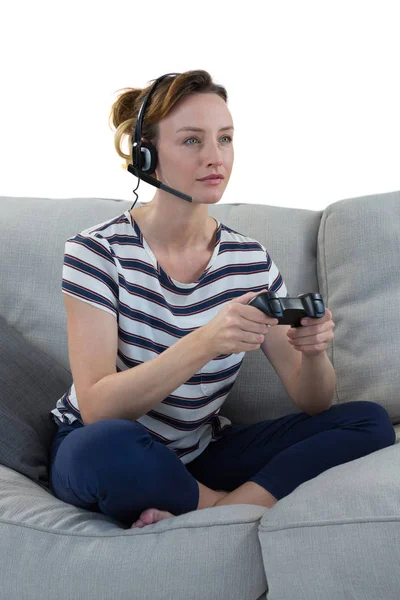Kvinna i hörlurar spelar videospel — Stockfoto