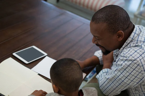 Vader helpt zijn zoon met huiswerk — Stockfoto