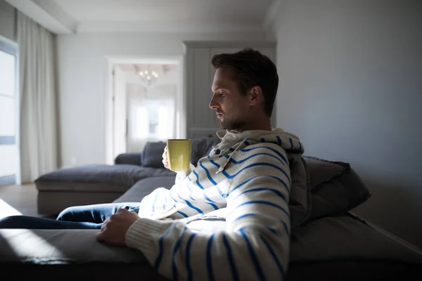 Мужчина пьет кофе в гостиной — стоковое фото