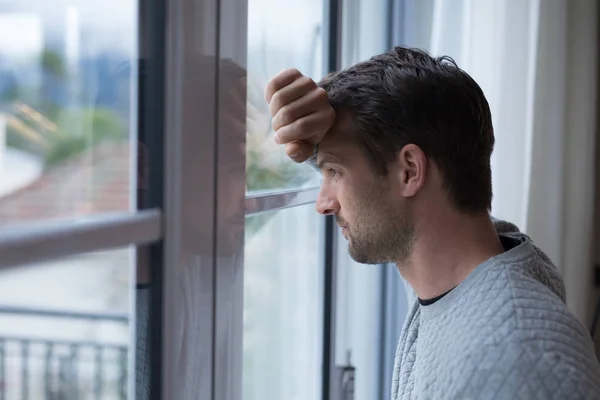 Thoughtful man looking through window — Stock Photo, Image