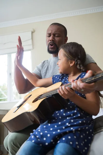 Vader leert dochter gitaar spelen — Stockfoto