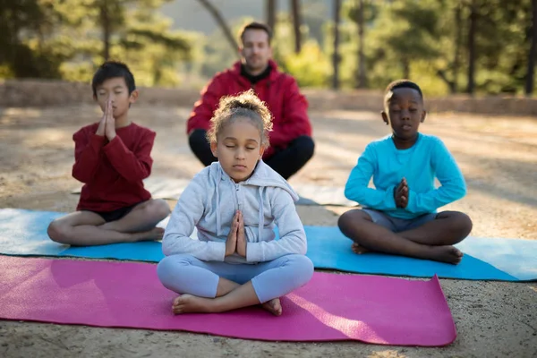 Coach e bambini che meditano nel parco — Foto Stock