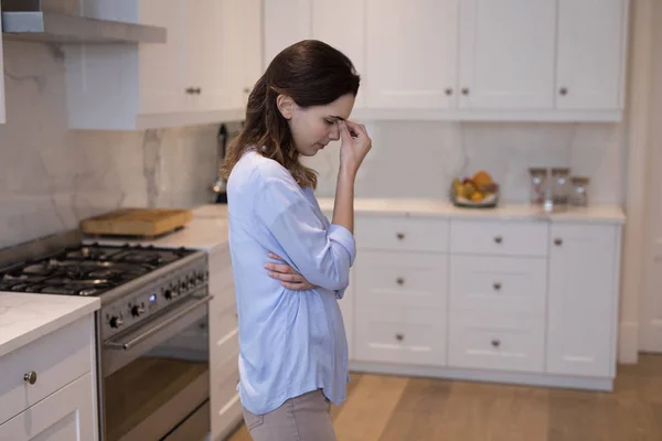 Беспокойная женщина стоит на кухне — стоковое фото