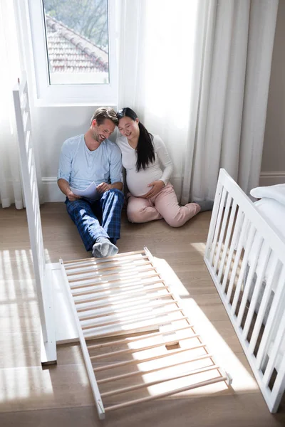 Affectionate couple sitting in bedroom — Stock Photo, Image