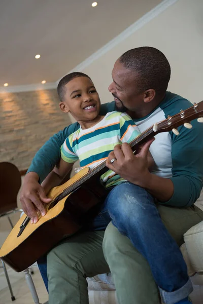 Vader onderwijs zijn zoon om gitaar te spelen — Stockfoto