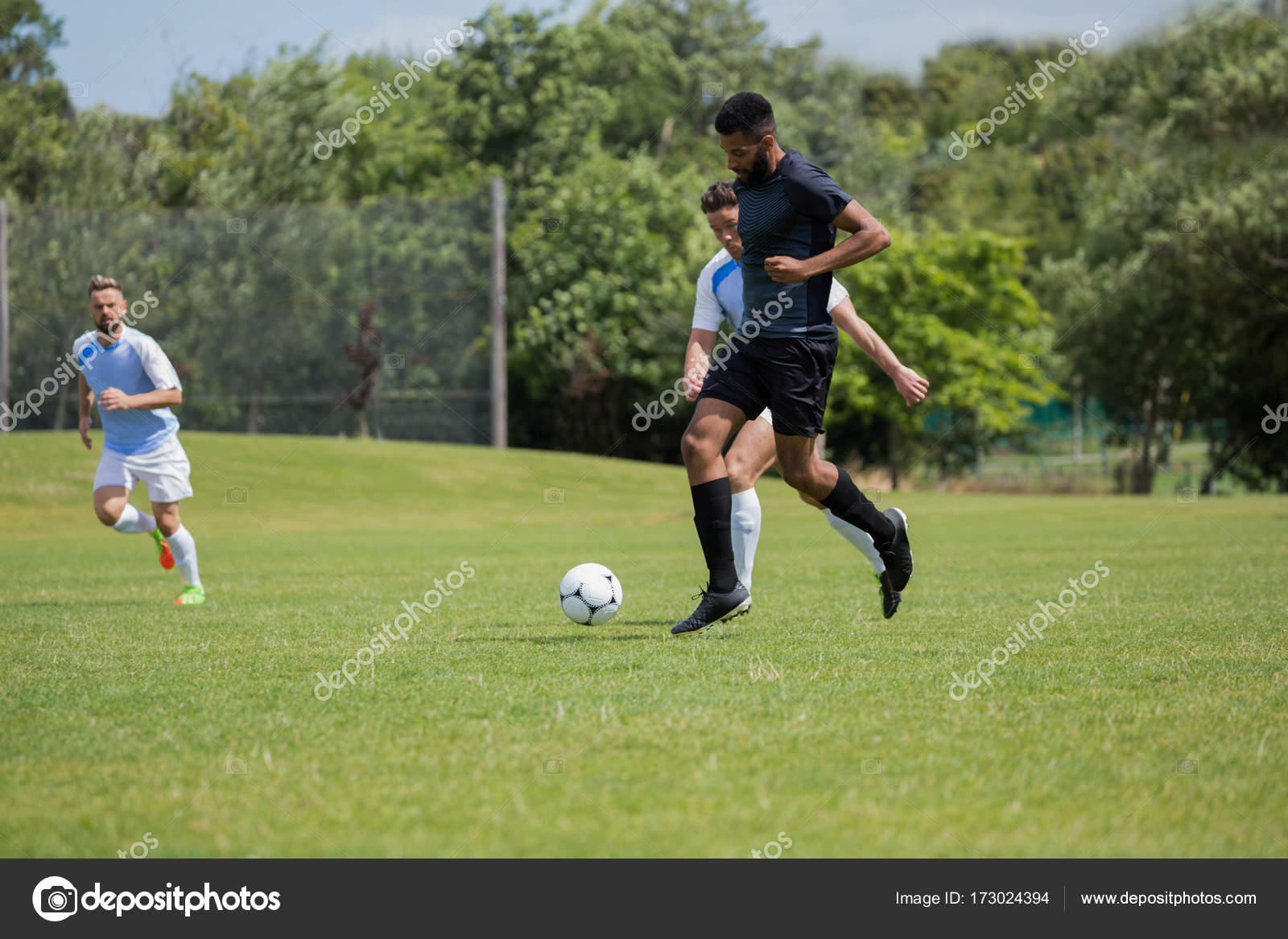 Football players playing soccer in the ground Stock Photo by